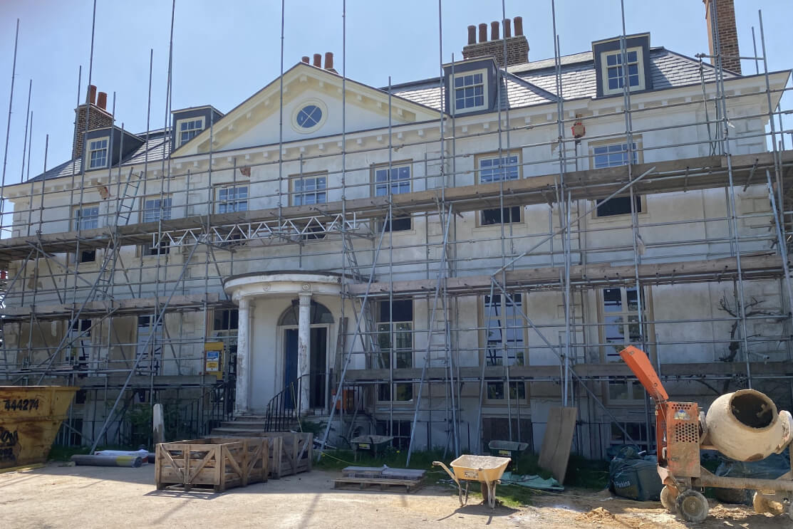 A period house under scaffolding for restoration of its timber soffits and roofline.